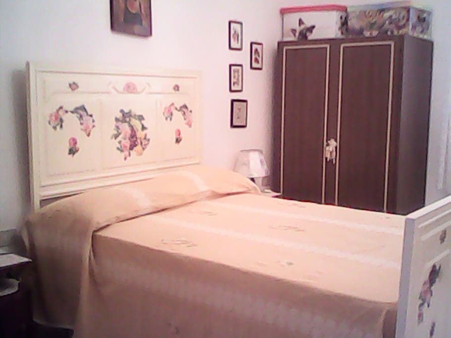 Camera arredata con letto alla francese, comò, armadio, comodini