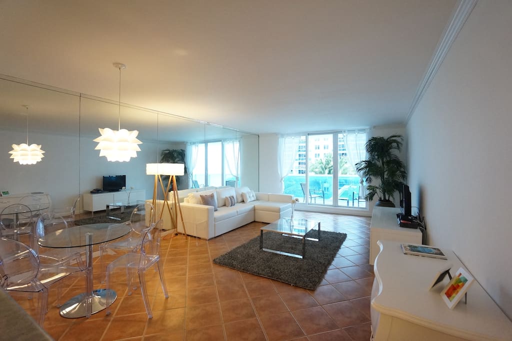 Living room with ocean view reflected in the mirrors and queen sofa bed
