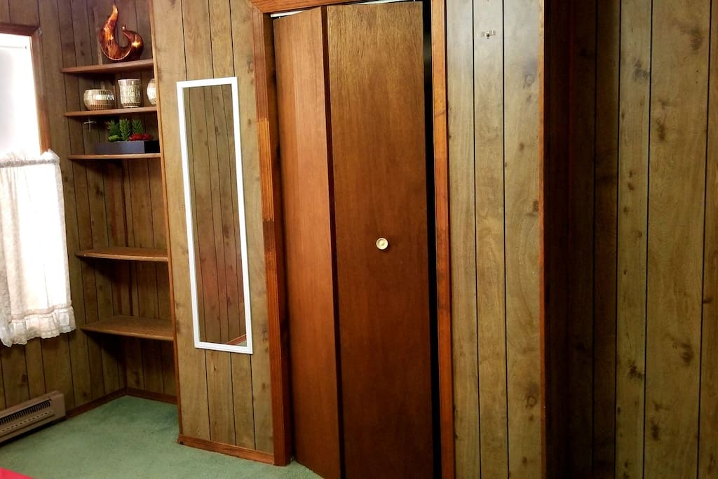 Built-in shelf unit, full length mirror, and closet with bi-folding doors.
