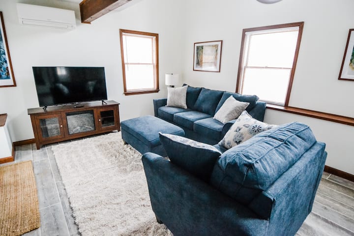 Cottage Living Room: the couch (which pulls out into a queen bed) and oversized chair beg guests to sink in and relax in front of the 4K TV and cozy electric fireplace.