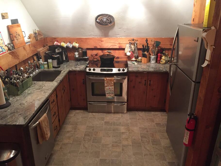 Fully equipped kitchen, with dishwasher, oven, fridge, microwave and granite countertops.