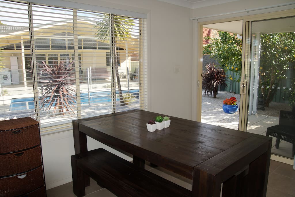 Dining table and view from inside the guesthouse overlooking the pool.