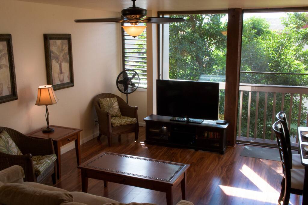Living room with flat-screen TV. Ceiling fans throughout house.