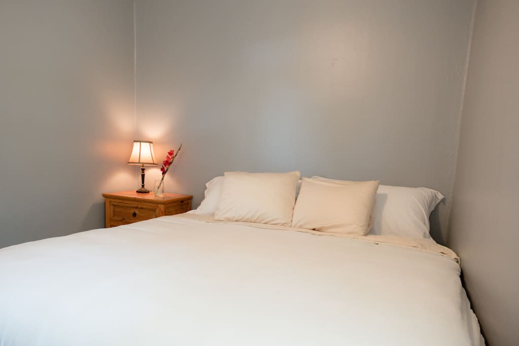 Lose yourself in the quiet luxury of Bedroom #1, with its king size pillow top bed, cozy down alternative comforter, crisp white sheets, extra pillows and calming grey walls. Newly-installed hardwood floors, plenty of outlets for your personal electronics, and a quiet ceiling fan to keep you comfortable.