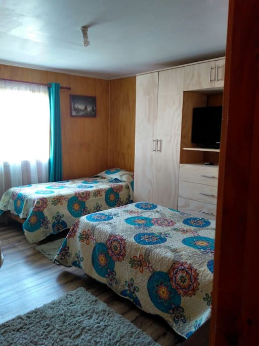 Dormitorio con 2 camas de 1 plaza y 1 cama de plaza 1/2, cuenta con closet y televisión con tv cable