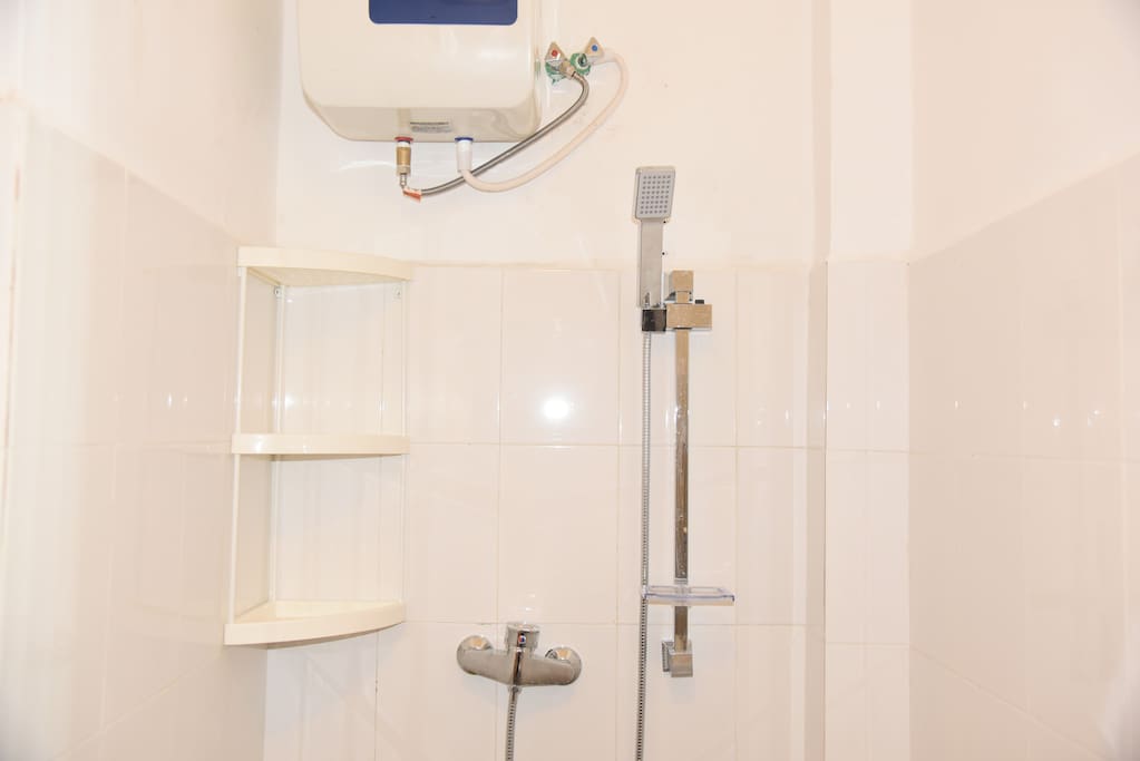 Private bathroom with hot shower, wash basin and toilet
