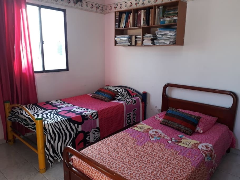 esta habitación tiene dos camas individuales y cuenta con armario su a abanico