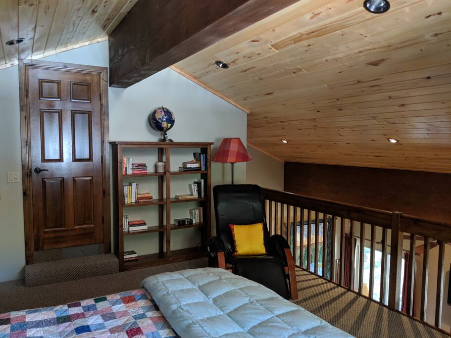 Upstairs bedroom has a massage chair so you can cozy up with a book comfortably. The door leads to the bathroom.