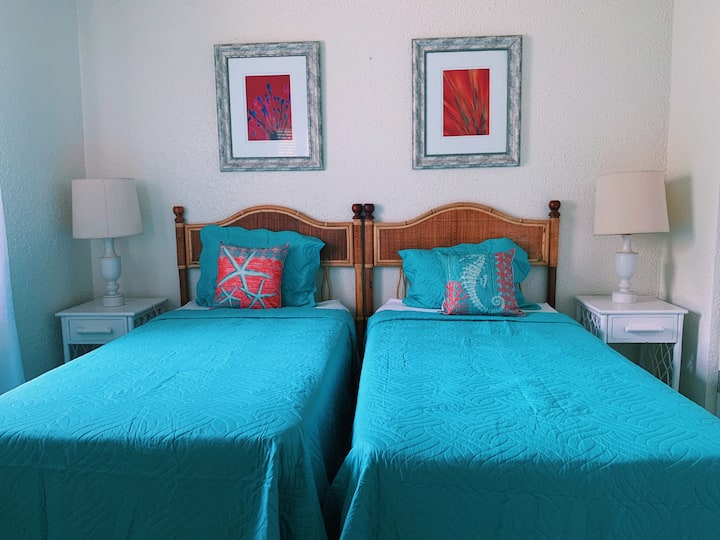 第二间海景主题卧室，配有两张单人床、空调和风扇