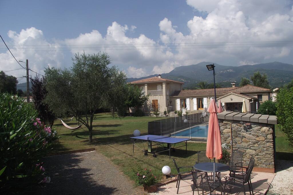 Gesamtansicht vom Boule Platz
(Petanque Platz, abends beleuchtet) auf den Garten, die Villa und am Horizont die korsischen Berge
