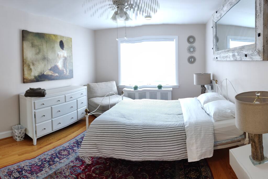 Master bedroom- Double (antique cast iron) bed, large windows, dresser, full length mirror, closet and shelves.