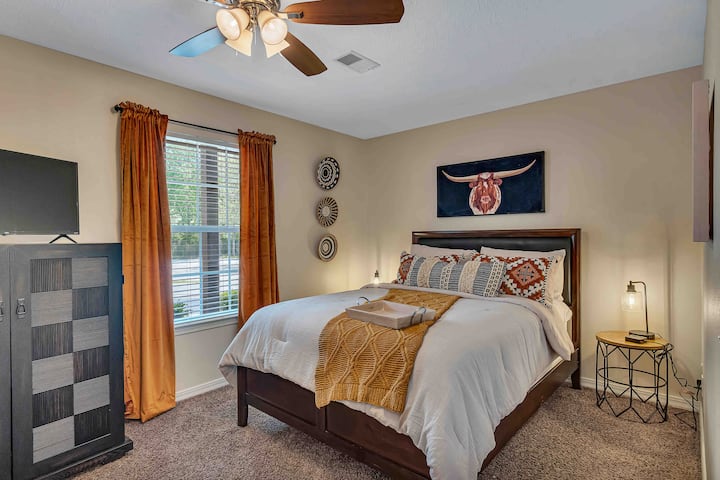 Rustic Charm and Dreamy Comfort: Unwind in our inviting bedroom adorned with warm tones and a unique Longhorn art piece above the plush queen size bed. Relax, watch your favorite shows on the TV, and sink into a serene slumber in this cozy haven.