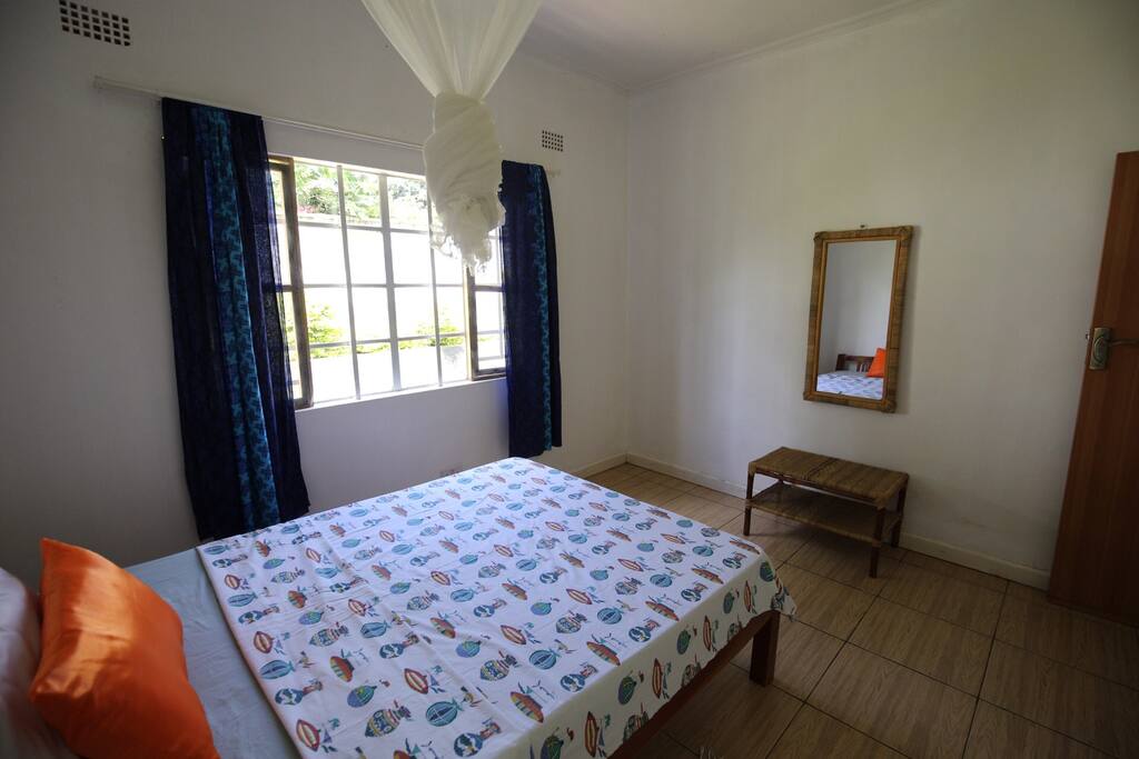 Guest room looking out into the garden. Dark curtains ensure a good night's rest.