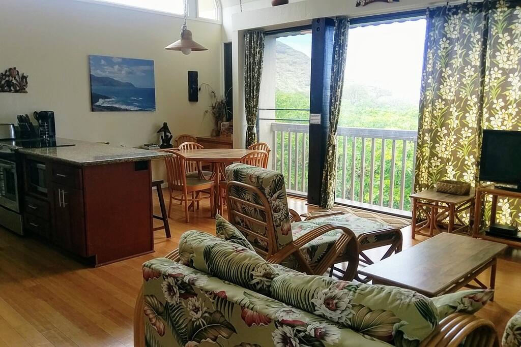 Upon entry is a great room with cathedral ceilings which is the living room, dining area, and kitchen