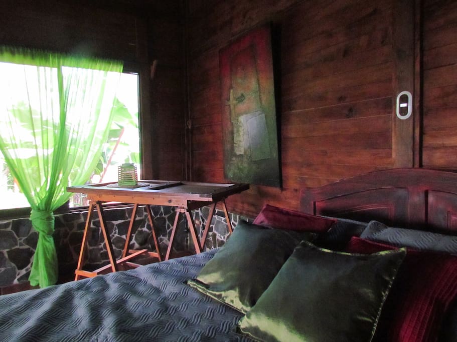 The cabain is made of rock and wood, pretty fresh, It has two sliding windows, the door slides too. Equipped with fan, nighstand, wardrobe, one King size bed and another individual, a lot of pillows and nice bed sheets.