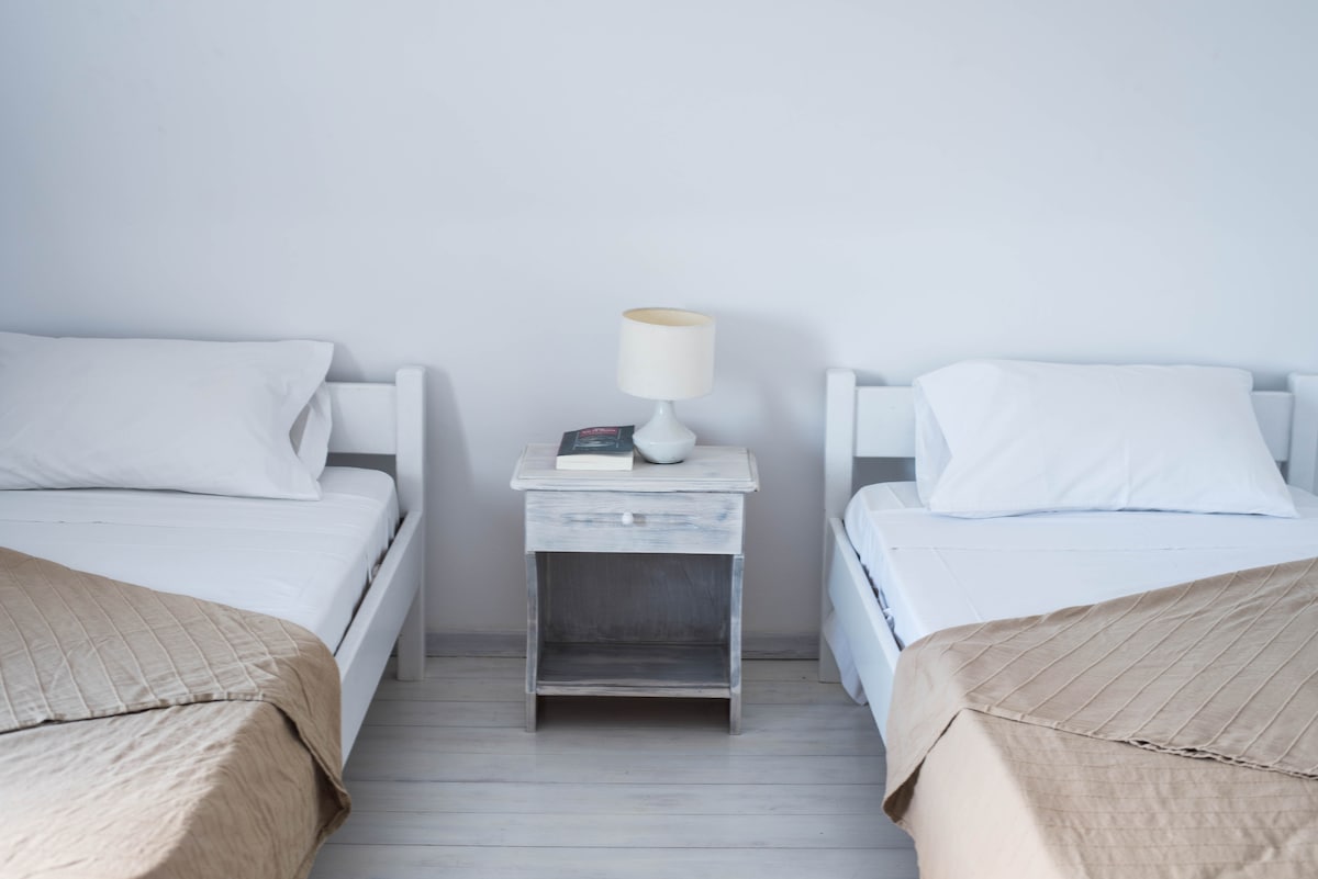 ห้องนอนโดม B พร้อมเตียงเดี่ยวสองเตียงลิ้นชักเสื้อผ้าและวิวทะเล