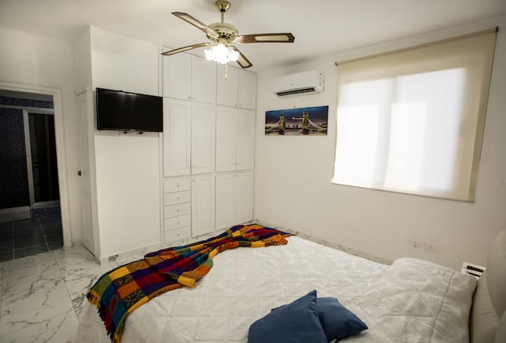 Habitación luminosa, airioso con su baño ,con un grande armario empotrado ,cama matrimonial grande con colchon made in Italia, split, tv plasma,caja fuerte, minibar, ventilador de techo, ventana grande  con cortinas .