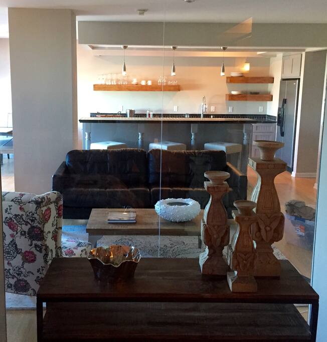 Bedroom looking into living room toward kitchen - all glass and open concept condo