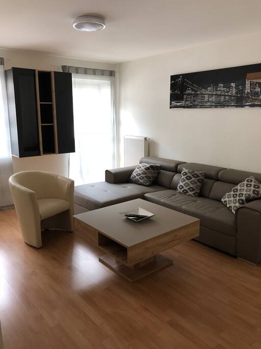 Wohnzimmer mit Balkonzugang und ausziehbarer Couch