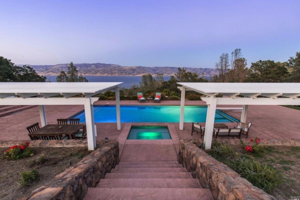 Expansive pool patio with hot tub overlooking the lake and mountains