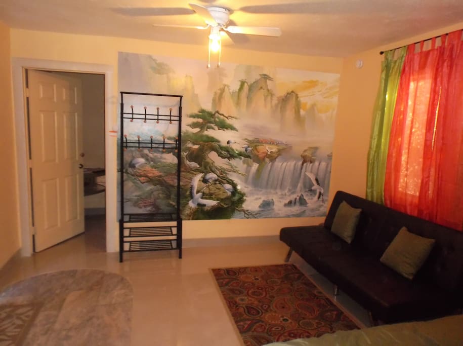 Bedroom: new futon, mural, coat hanger, ceiling fan ,door to the closet