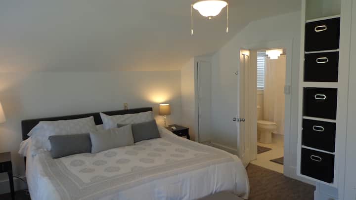 Master bedroom with king bed and  entry to full bathroom