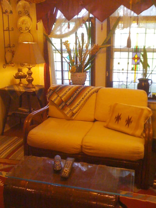 Living Room has stained glass windows. Ratan couch is comfortable. Western Decor