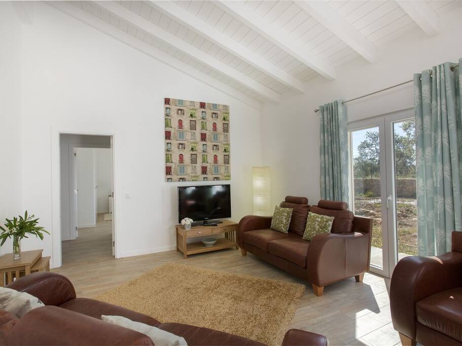 French doors lead directly to a terrace and landscaped gardens and onto the pool