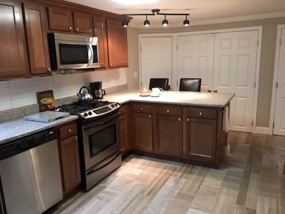 Full kitchen with granite countertops, oven, dishwasher, microwave and fridge with ice maker