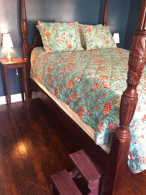 four-post, engraved wooden bed with pillow top mattress