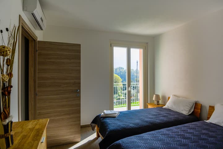 Treća spavaća soba s bračnim krevetima s balkonom i pogledom na jezero na prvom katu