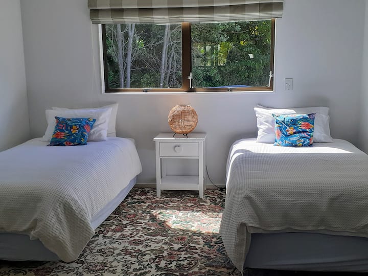 ห้องนอนเตียงแฝดพร้อมแสงแดดยามบ่ายและวิวสวน