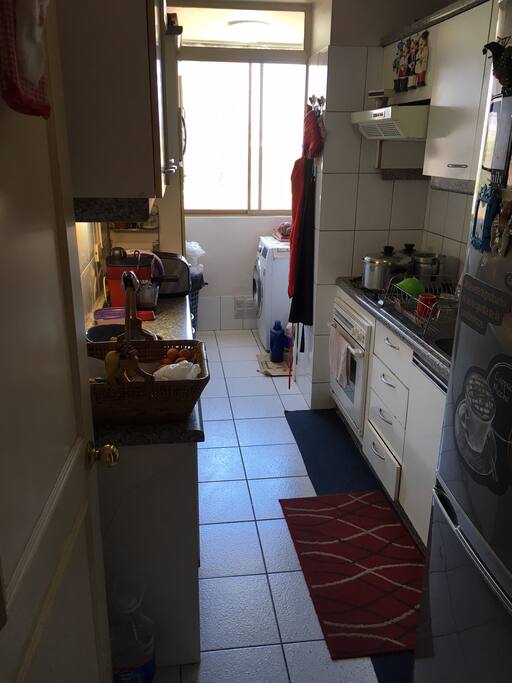 Cocina con encimera de 4 platos, horno eléctrico, microondas, lavadora y secadora