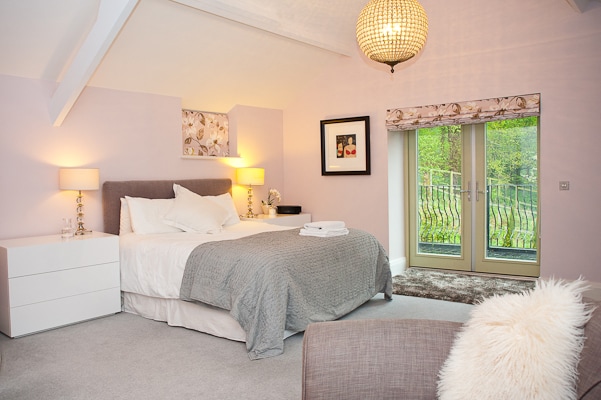 ห้องนอนใหญ่พร้อมเตียงคิงไซส์พิเศษและระเบียงคู่ห้องพักกว้างขวางและสว่างพร้อมห้องน้ำในตัวขนาดใหญ่ 