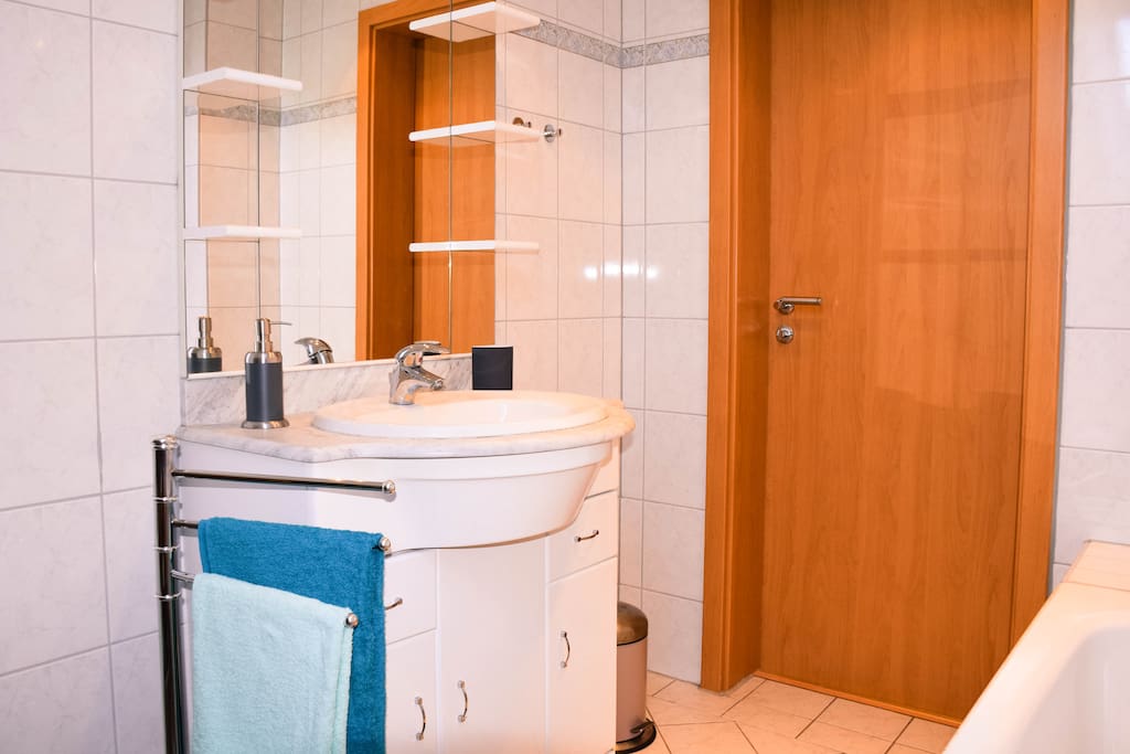 Ein großer Spiegel über dem Waschbecken lässt den Raum noch heller wirken