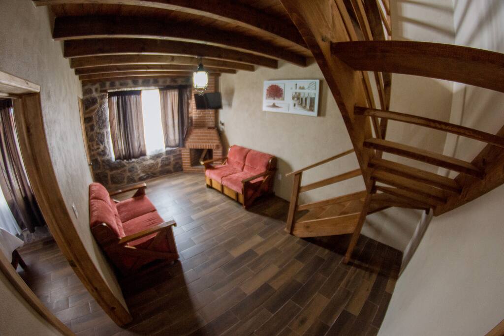 Sala de estar en la primera planta, cuenta con baño, televisor, sala y chimenea