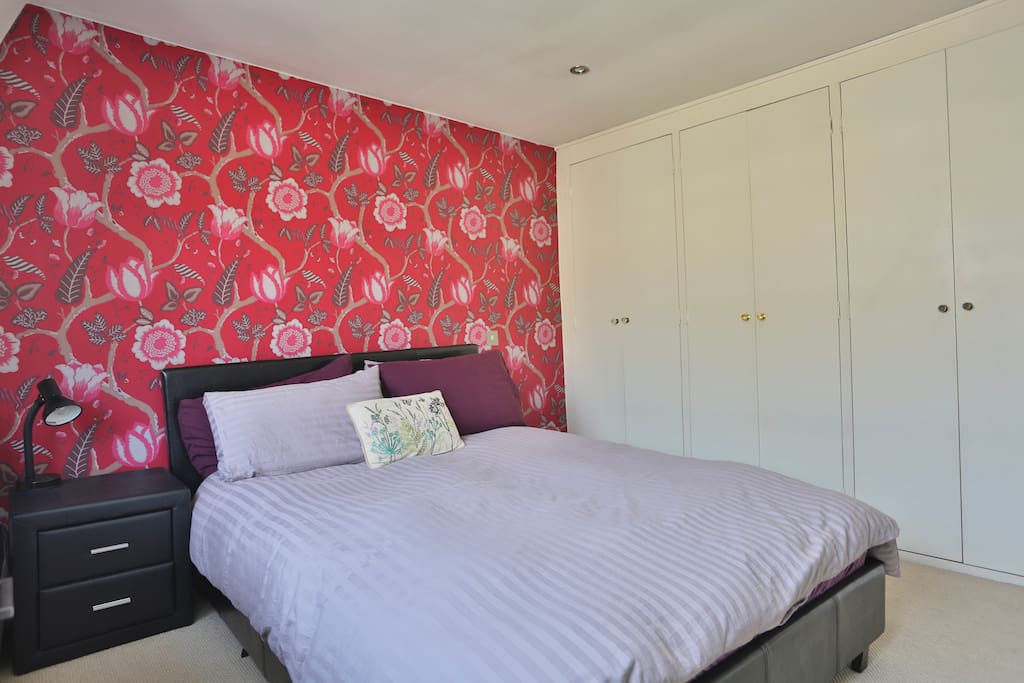 The master bedroom is spacious, with plenty of storage space and a double bed