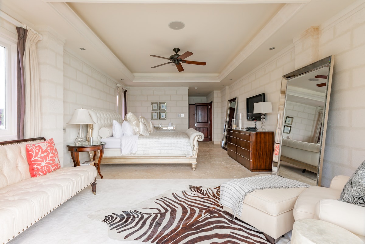 Maluwag at marangyang master bedroom na may king size bed, air conditioning, ceiling fan, Smart TV, Sonos system, security safe, shared balcony, walk in wardrobe at magandang en suite na banyo.