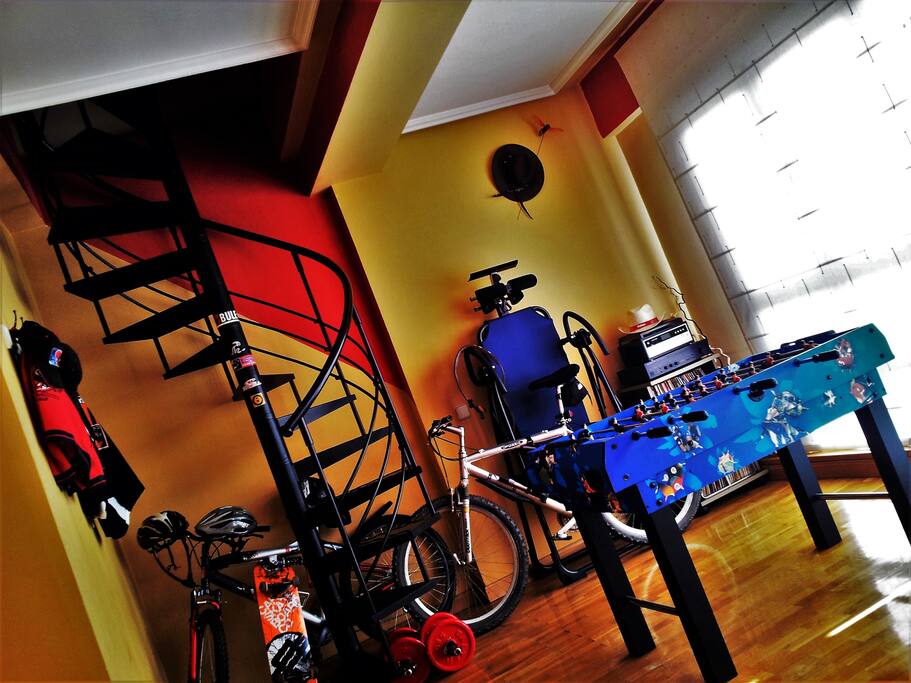 SALÓN CON LOS DISTINTOS UTENSILIOS A DISPONIBILIDAD DE LOS HUESPEDES!!! APARATO DE COLGARSE, BICICLETAS Y PATINETES Y UN FUTBOLÍN CON NUEVE JUEGOS MÁS.