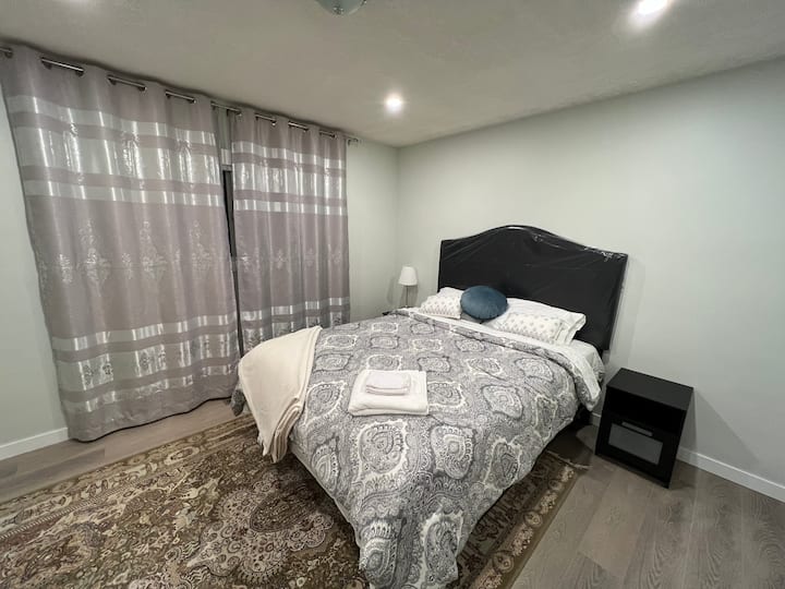 غرفة نوم رئيسية واسعة جدًا مع مرتبة كوين جديدة تمامًا وسرير وسجاد فارسي. 