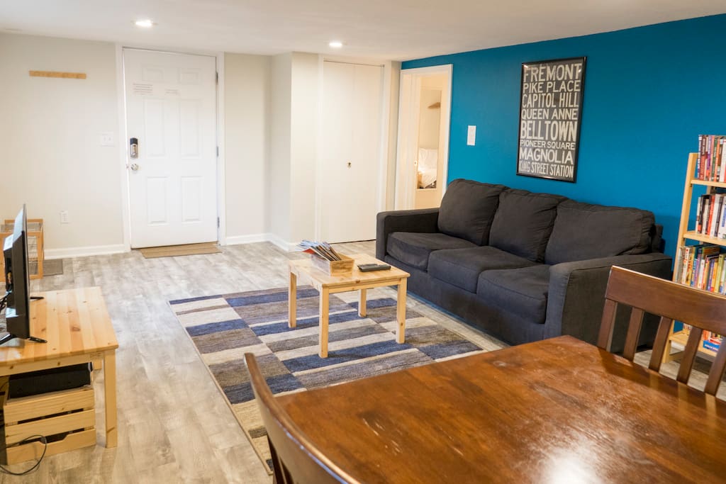 A comfortable and open living room! Features a queen-sized pull-out sofa bed with a memory foam mattress. Relax after a long day of exploring to a Roku-enabled TV and a wide-selection of books. The spacious dining table doubles as a working desk for business travelers.