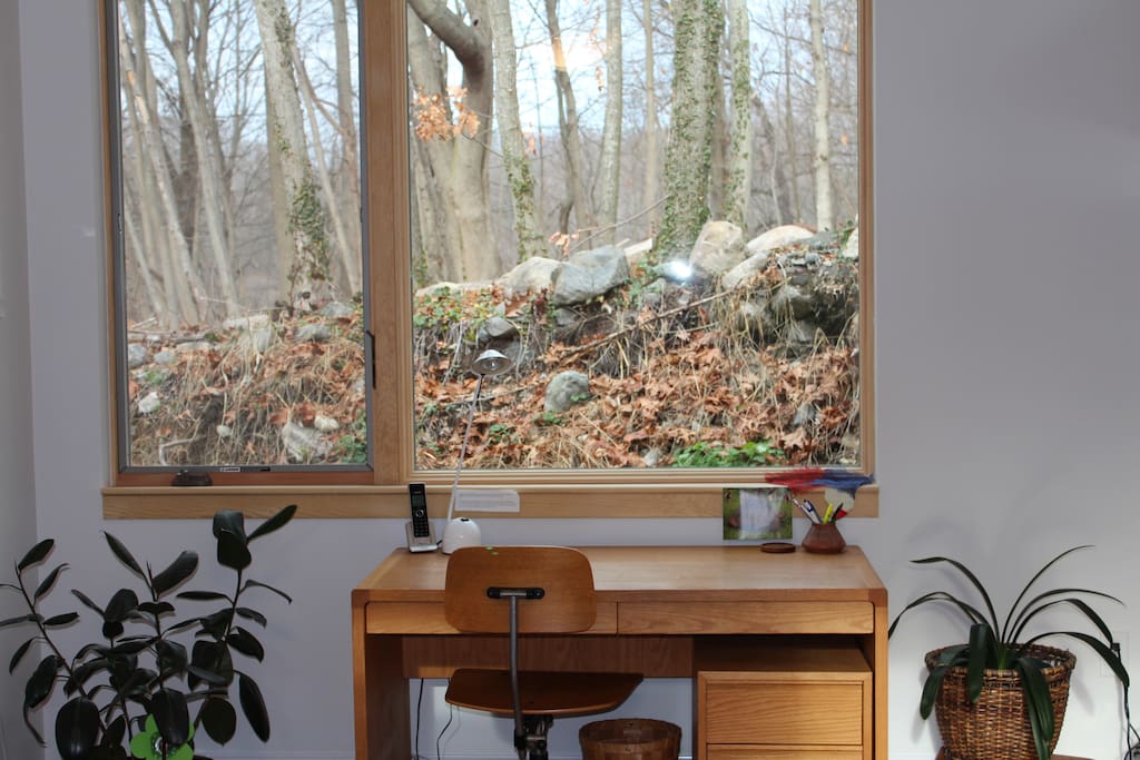Desk for writing, reflecting looks out to old stone wall and conservation land.