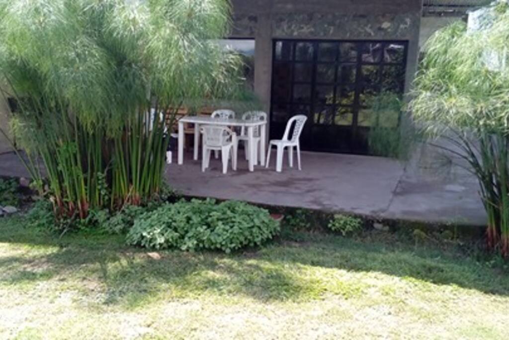amplia galeria con asador y mesa de jarddin
