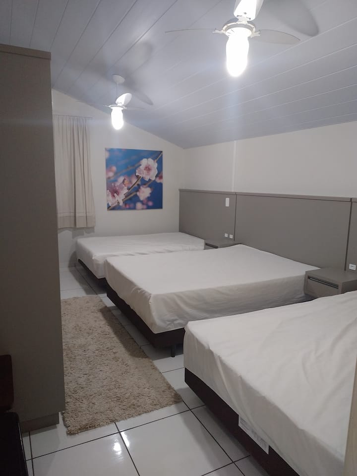 ห้องพักพร้อมเตียงคู่ 3 เตียงเครื่องปรับอากาศและพัดลมเพดาน 2 ตัว