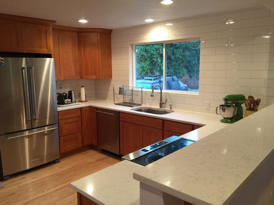 Newly remodeled kitchen with new floor, appliances, cabinets and countertops. The new bar in foreground is the viewpoint into the living room and great for entertaining and groups.