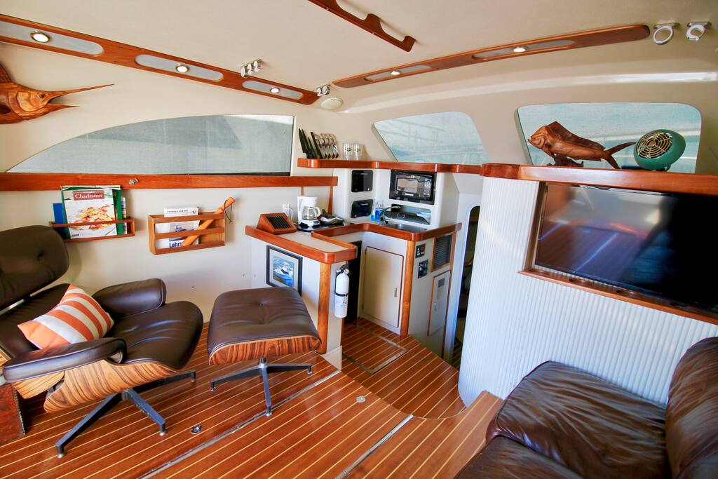 Spacious salon (living room) with a 40” LCD tv, premium leather couch & extra comfy eames lounge chair.