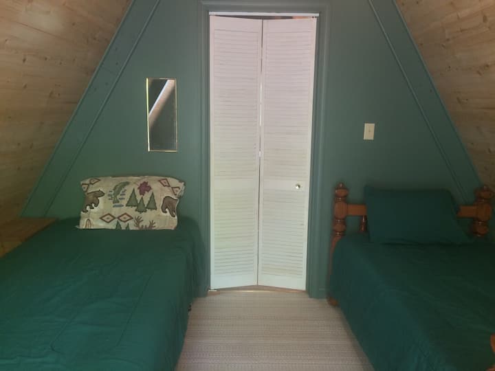 El primero de los dos dormitorios del segundo piso.  Dos camas individuales y un pequeño balcón