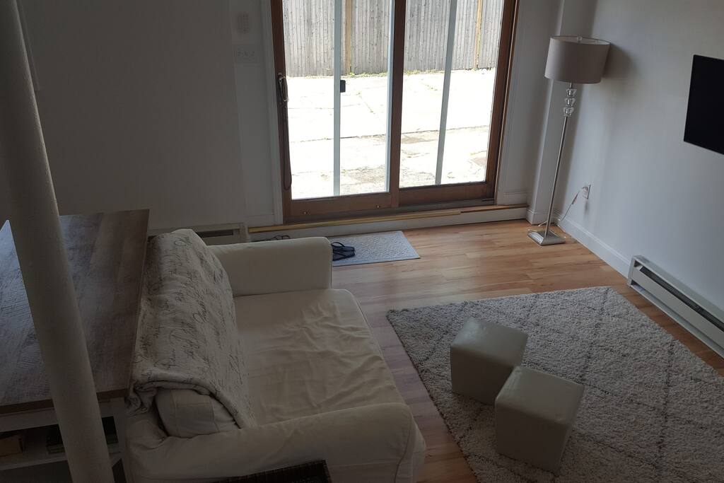 downstairs living space with pullout couch, breakfast bar, mounted TV, and guest bath