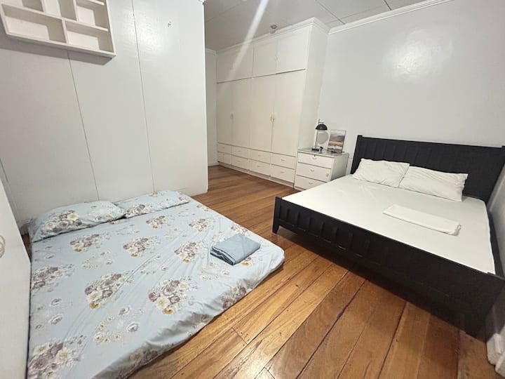 The Master Bedroom is equipped with a queen-sized bed and an additional queen-sized mattress, comfortably accommodating up to four guests. The room also features an attached bathroom for added convenience.