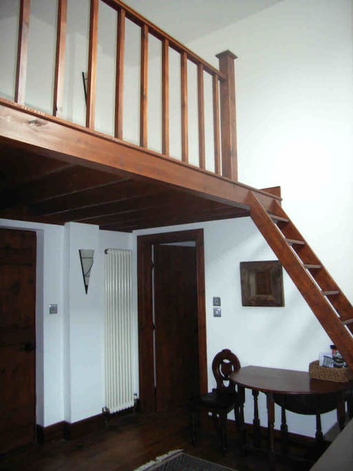 dining table, mezzanine above with single mattress